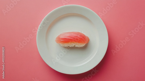 A beautifully crafted piece of sushi resting on a white plate against a vibrant pink background photo