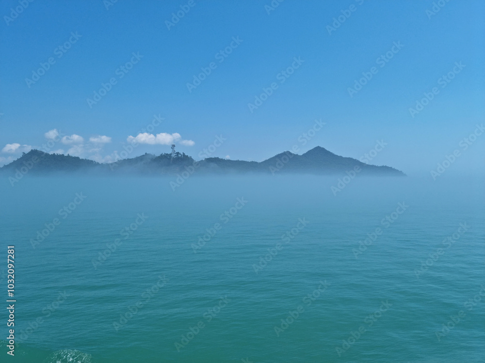 It is a foggy sea and island. It is a foggy sea and island.