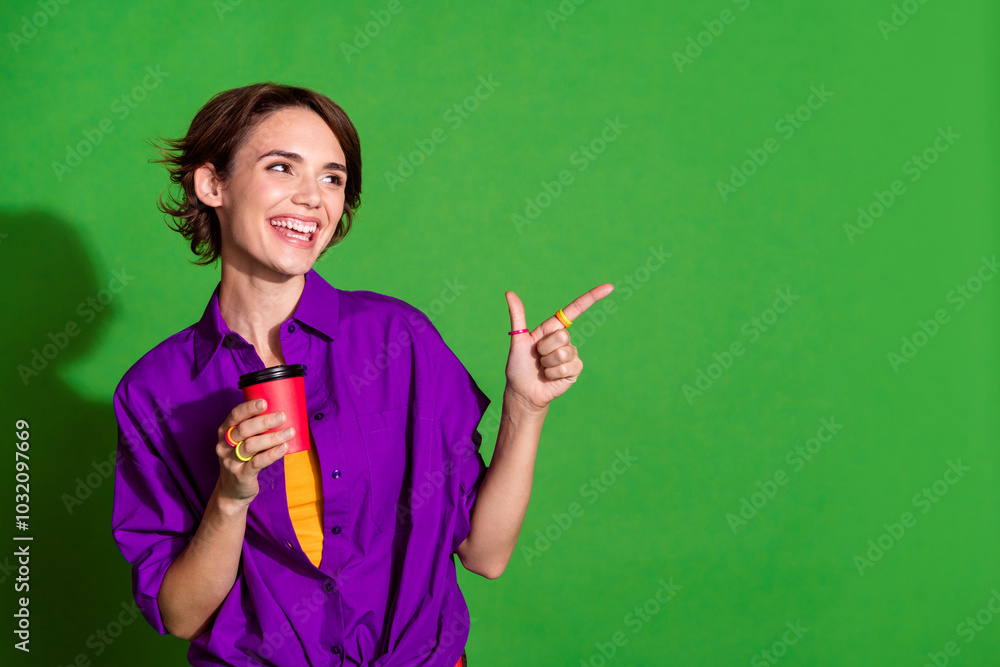 Photo of young lady in purple shirt coffee break directing finger copyspace restaurant enjoying fresh espresso isolated on green color background Photo of young lady in purple shirt coffee break directing finger copyspace restaurant enjoying fresh espresso isolated on green color background