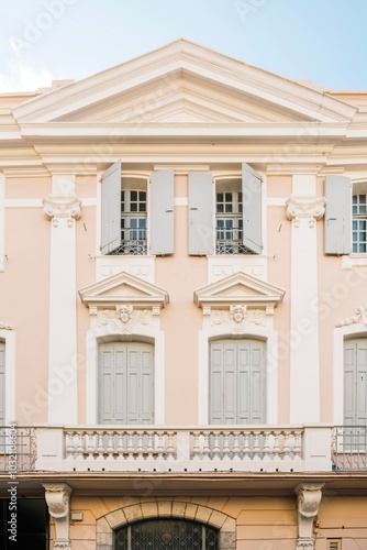 Facade of a colonial building with symmetrical windows and iron balconies in the French town of Perpignan.