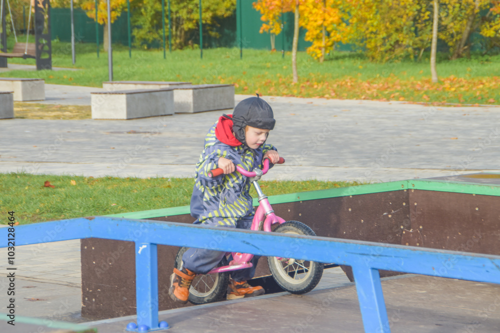 a child, a boy riding a running bike, a bicycle on a sports field, a photo without filters a child, a boy riding a running bike, a bicycle on a sports field, a photo without filters