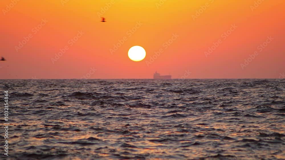 Sunrise over the sea and a passing ship Sunrise over the sea and a passing ship
