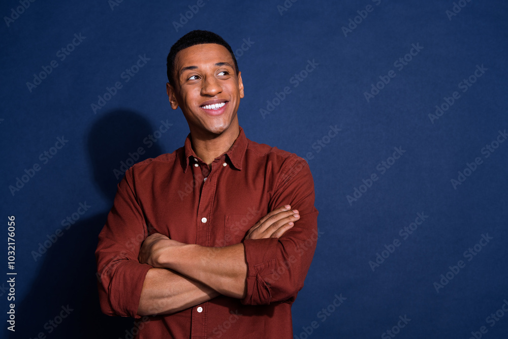 Photo of dreamy cool guy dressed brown shirt arms crossed looking emtpy space isolated blue color background Photo of dreamy cool guy dressed brown shirt arms crossed looking emtpy space isolated blue color background