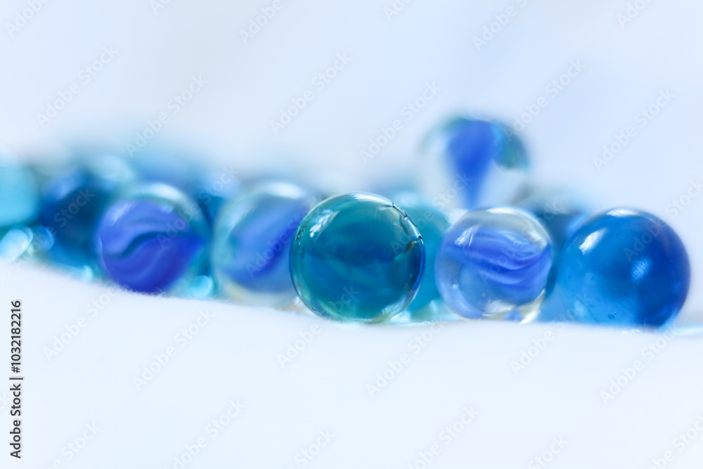 blue glass marbles on a white background close-up, macro photography blue glass marbles on a white background close-up, macro photography