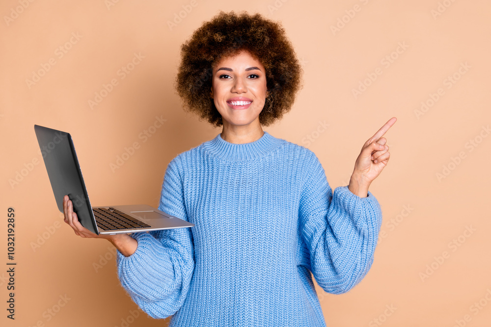 Photo of positive girl with chevelure dressed blue sweater hold laptop directing at offer empty space isolated on pastel color background Photo of positive girl with chevelure dressed blue sweater hold laptop directing at offer empty space isolated on pastel color background