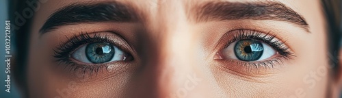 Close-up of a captivating person with vibrant blue eyes, showcasing detailed eyelashes and natural beauty. Perfect for portrait or beauty concepts.