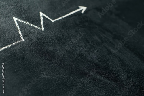 A close-up of a blackboard featuring a white chalk graph arrow pointing upwards, symbolizing growth, success, and progress in education or business.