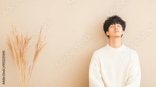 Peaceful Reflection of a Young Asian Man in Minimalist Setting with Natural Light photo