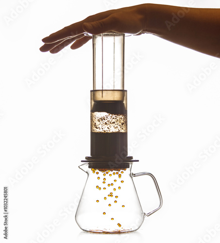 Barista Making Aeropress Technique of Coffee Brewing as Coffee Drops Fall Into Glass Kettle photo