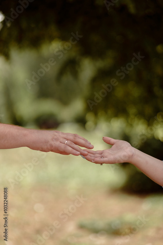 A couple in love touches each other with their hands. Love story of a young couple in love. Wedding rings on ring fingers. Concept of a marriage proposal. Starting a family.