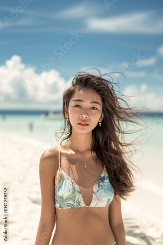 Young Woman in Floral Bikini Relaxing on a Sunny Beach with Wind in Her Hair