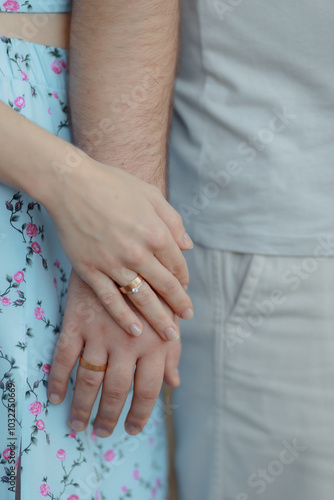 A couple in love touches each other with their hands. Love story of a young couple in love. Wedding rings on ring fingers. Concept of a marriage proposal. Starting a family.