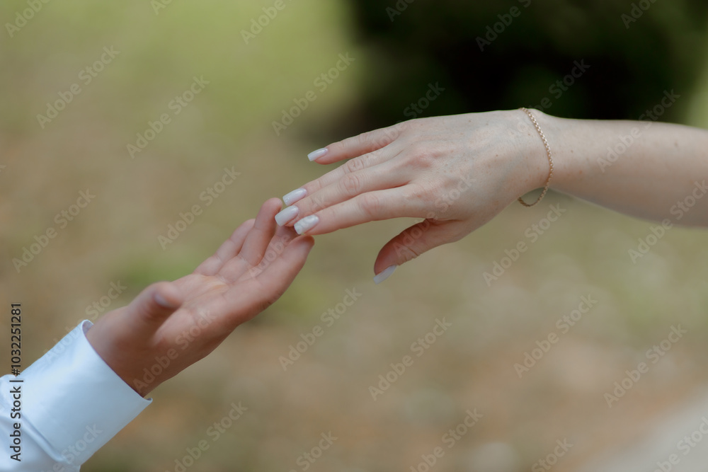 A couple in love touches each other with their hands. Love story of a young couple in love. Wedding rings on ring fingers. Concept of a marriage proposal. Starting a family. A couple in love touches each other with their hands. Love story of a young couple in love. Wedding rings on ring fingers. Concept of a marriage proposal. Starting a family.