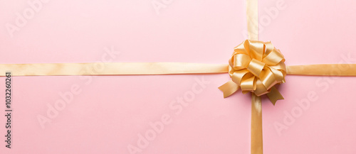 Top view of gold ribbon rolled and yellowbow isolated on colored background. Flat lay with copy space photo