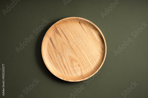 Wooden flat plates on a green background. The concept of ecological tableware. Products for modern kitchen. Zero emissions. photo