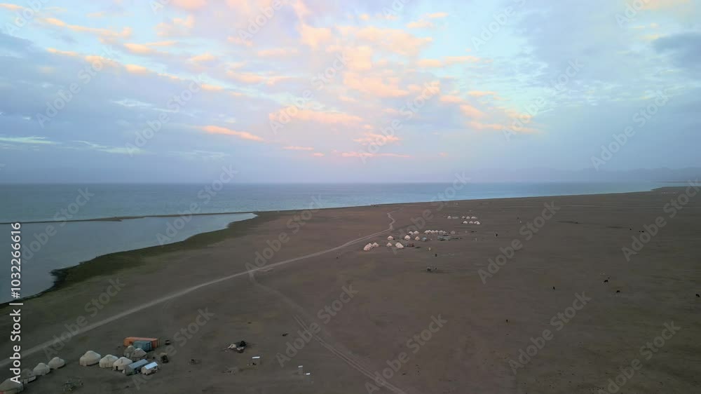 Sunrise in Song-Köl Lake, Kyrgyzstan. Drone footage of nomad yurts camps in beautiful Kyrgyz mountain scenery. Slow aerial travelling panning down in famous touristic destination of Central Asia Sunrise in Song-Köl Lake, Kyrgyzstan. Drone footage of nomad yurts camps in beautiful Kyrgyz mountain scenery. Slow aerial travelling panning down in famous touristic destination of Central Asia