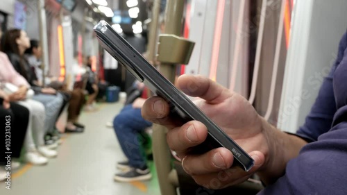Man using smartphone in subway train. Lifestyle concept. Activities in public transport. Person addicted to social network, technologies, media