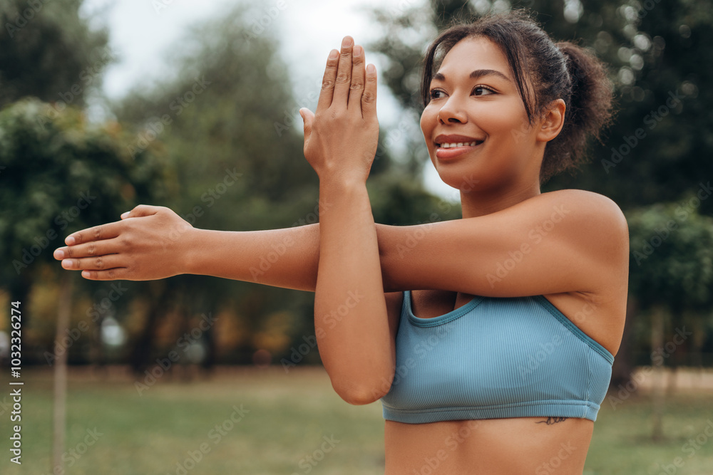 Portrait of smiling cheerful African American woman warming up, looking away on the street, outdoors Portrait of smiling cheerful African American woman warming up, looking away on the street, outdoors