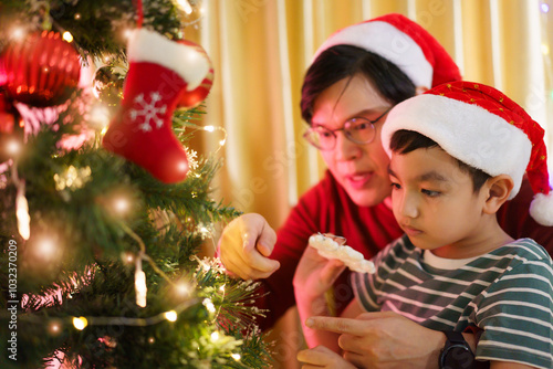 Lovely Asian family father and son are celebrating Christmas and New Year dinner party together.