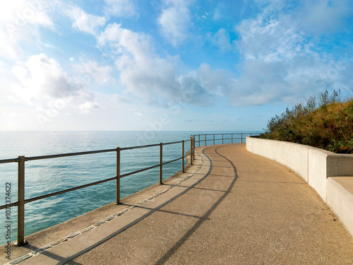A 390 metre seawall construction built to protect further erosion and stabilise the cliffs along the  coastline east of Lyme Regis in Dorset captured on a sunny day with soft fluffy clouds