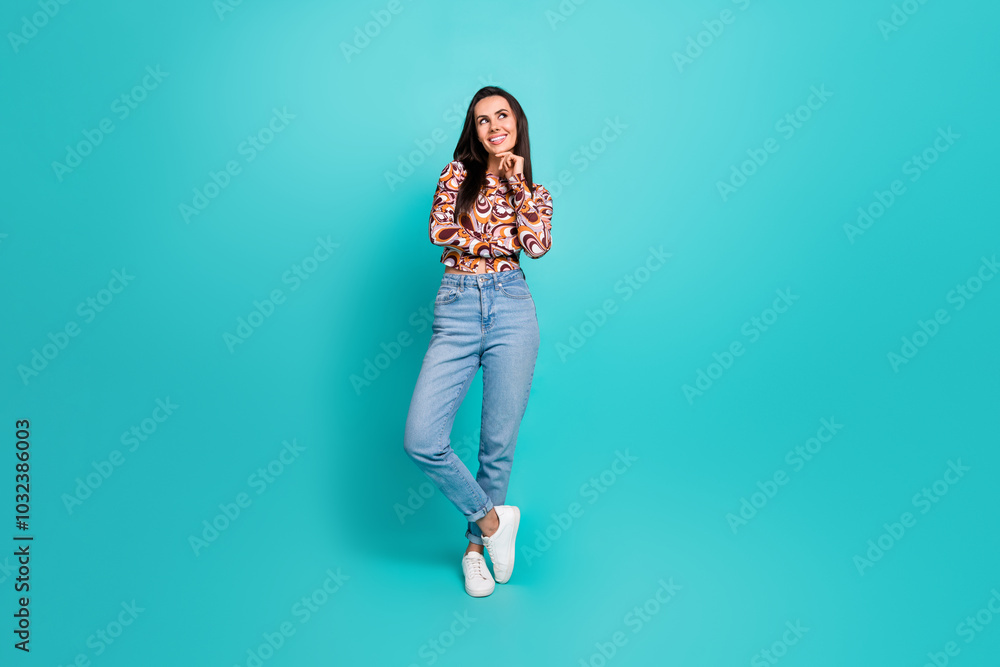 Full length photo of dreamy pretty lady dressed retro shirt arm chin looking empty space isolated blue color background Full length photo of dreamy pretty lady dressed retro shirt arm chin looking empty space isolated blue color background