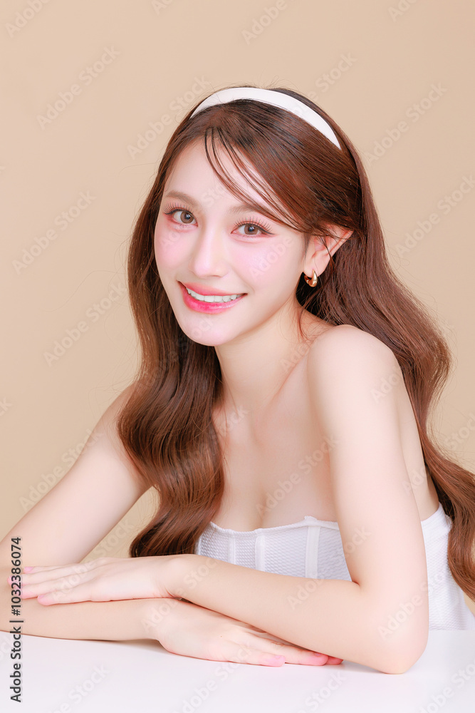 Pretty Asian beauty woman curly long hair with Korean makeup glowing face and healthy facial skin portrait smile on isolated beige background. Cosmetology ,Plastic surgery. Pretty Asian beauty woman curly long hair with Korean makeup glowing face and healthy facial skin portrait smile on isolated beige background. Cosmetology ,Plastic surgery.