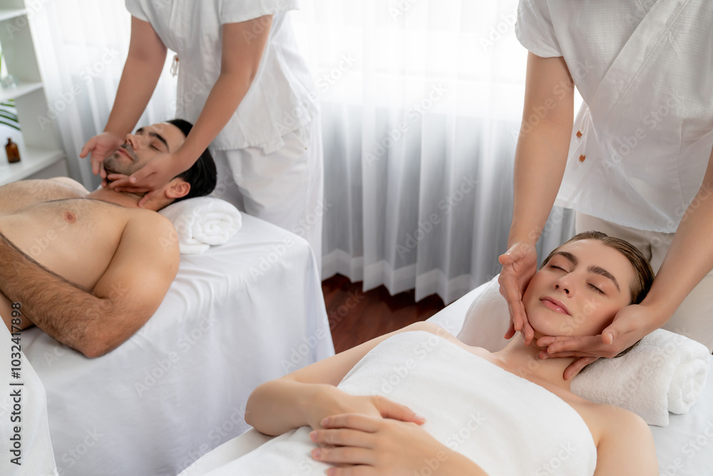 Obraz premium Caucasian couple enjoying relaxing anti-stress head massage and pampering facial beauty skin recreation leisure in dayspa modern light ambient at luxury resort or hotel spa salon. Quiescent
