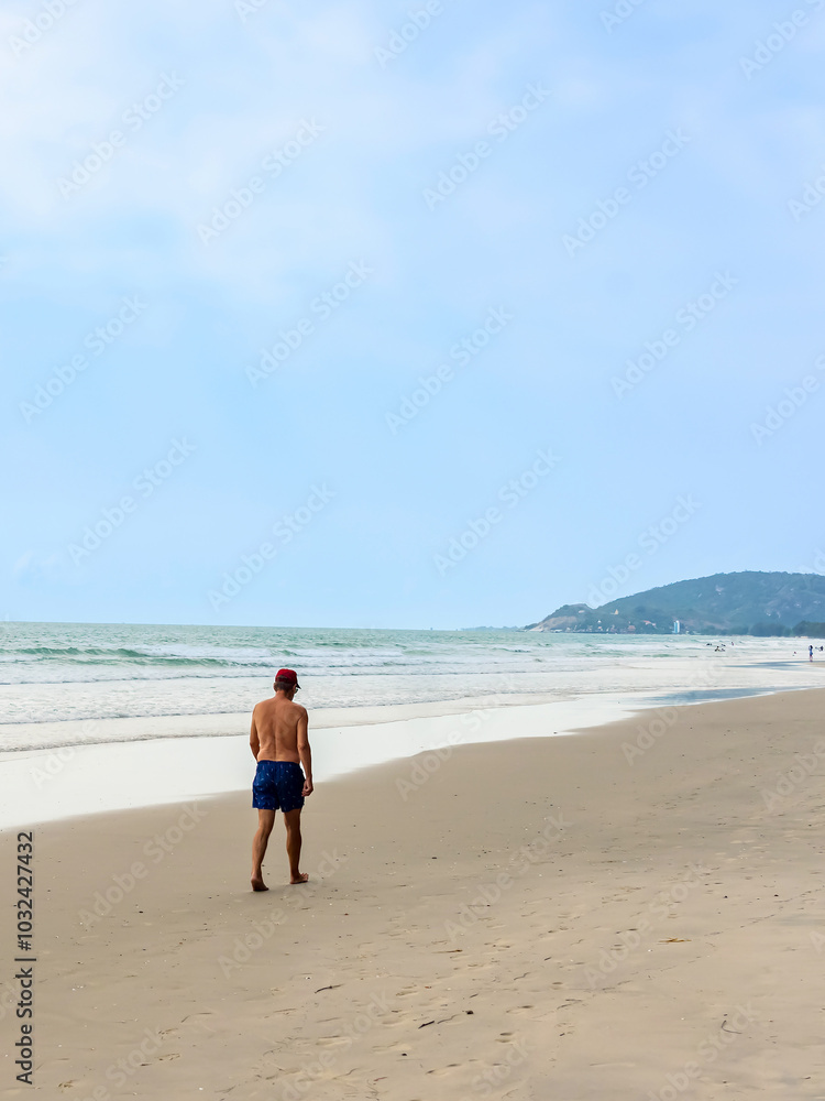 Back view of senior man walking on beach. Portrait happy senior man while walking along the beach, concept of senior lifestyle, travel, relaxing in nature. Happy man walking on coastline at beach. Back view of senior man walking on beach. Portrait happy senior man while walking along the beach, concept of senior lifestyle, travel, relaxing in nature. Happy man walking on coastline at beach.