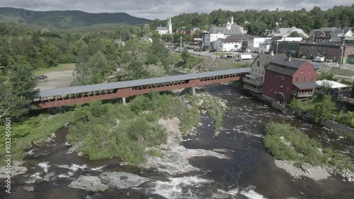 Riverwalk Covered Bridge on Ammonoosuc river surrounded by forests and buildings in New Hampshire photo