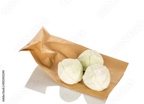 Sweet delicious pear marshmallow on paper bag, macro, isolated on white background.