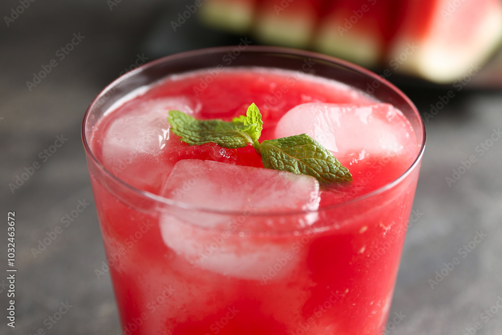 Tasty watermelon drink in glass and mint on blurred background, closeup Tasty watermelon drink in glass and mint on blurred background, closeup
