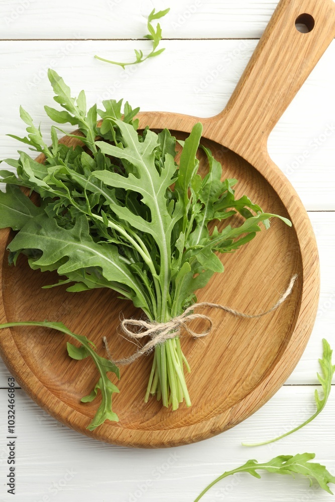 Bunch of fresh green arugula leaves on white wooden table, top view