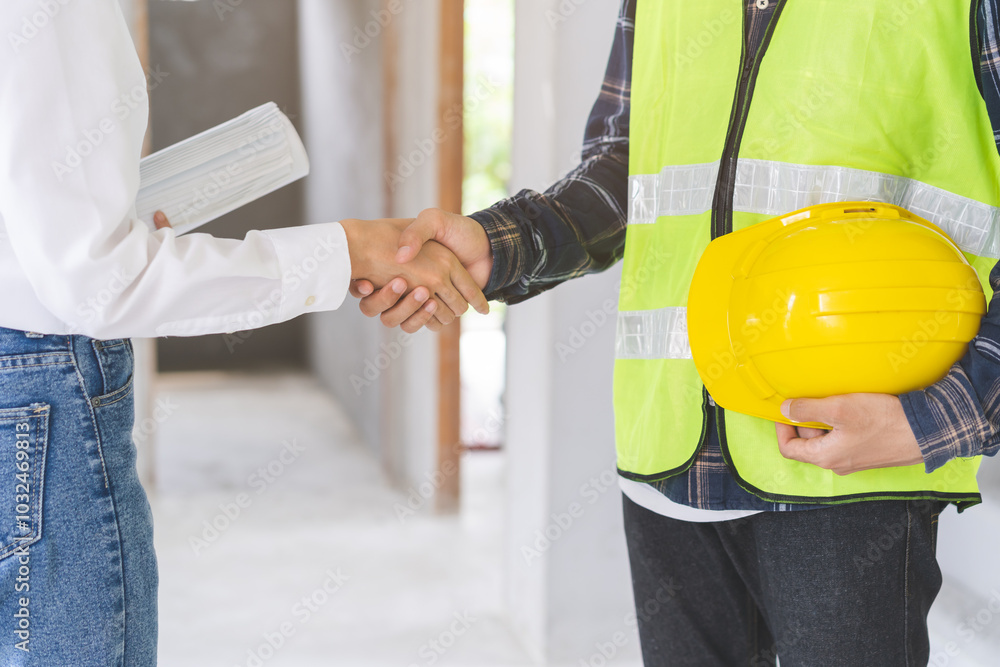 Engineer team building, teamwork contractor, two asian young partnership, builder agreement handshake plan home project contract at construction site .Happy architect, surveyor worker shaking hand. Engineer team building, teamwork contractor, two asian young partnership, builder agreement handshake plan home project contract at construction site .Happy architect, surveyor worker shaking hand.