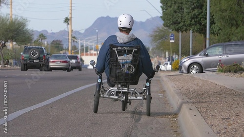 Person Riding Adaptive Tricycle on Urban Street with Helmet for Safe Commute