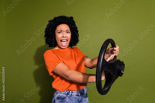 Canvas Print Photo of pretty young woman beep horn wheel wear orange t-shirt isolated on khak