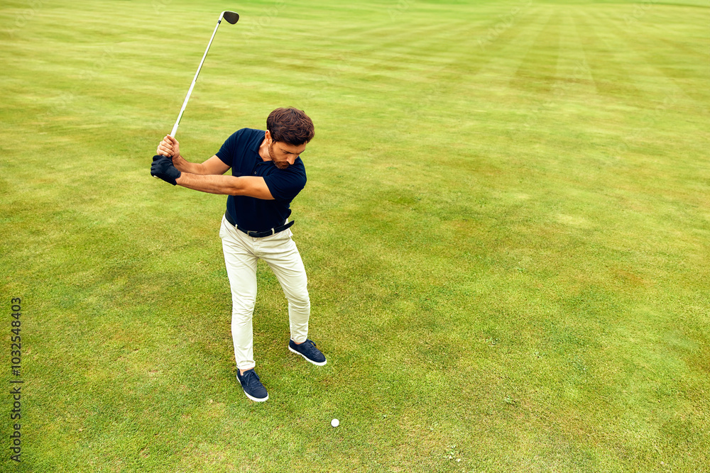 Obraz premium A Young Golfer Enthusiastically Swinging a Golf Club on a Lush and Vibrantly Green Field