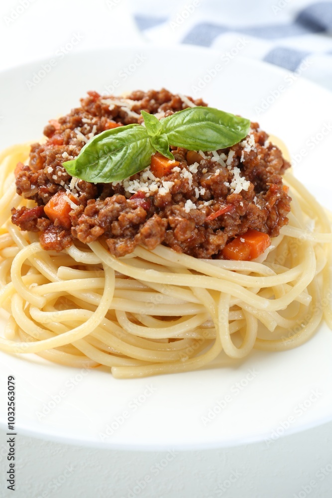 Tasty pasta bolognese with basil on white table, closeup Tasty pasta bolognese with basil on white table, closeup