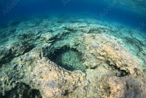 Underwater landscape with stones, blue ocean, rocky seabed. Underwater snorkeling photography, seascape with rocks. Travel photo, adventure trip.