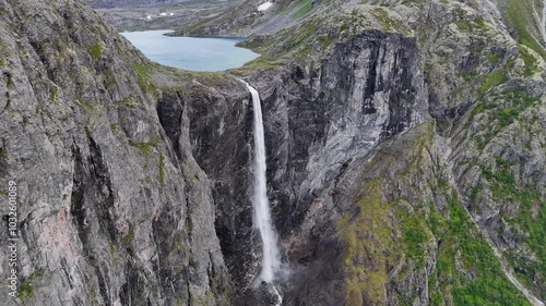 The drone zooms in and rises slowly behind mountains and Mardalsfossen in Eikesdal comes into view. The waterfall is one of the tallest waterfalls in Europe. A whopping 705 meters of waterfalls. 4K. photo