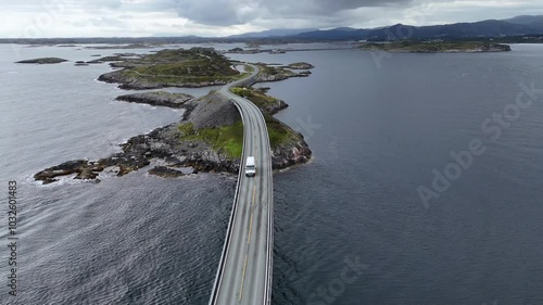 Aerial view of a car crossing Storseisundet bridge on Atlantic Road (Atlanterhavsveien) also known as ”The Road in the Ocean” in Norway. National Tourist Route in 4K drone shot.