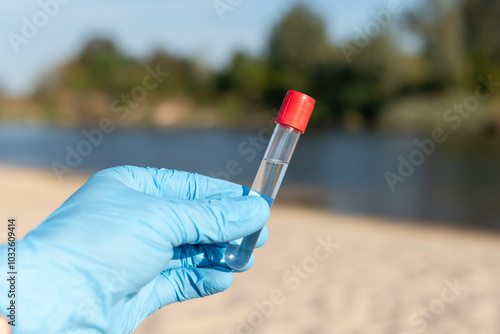 Photos Hand in blue medical glove with test tube