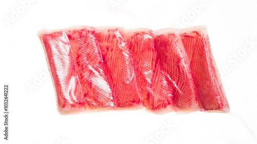 Packing and Freezing Crab Sticks. Crab sticks are vacuum packed and rapidly cooled with an ice jet, creating the effect of white steam on a white background photo