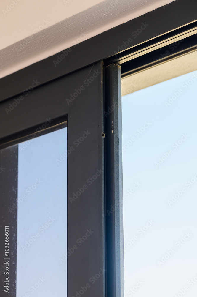 A Close-Up View of a Sleek Modern Sliding Door Frame Showcasing Minimalist Design and a Clear Blue Sky in the Background During Daylight A Close-Up View of a Sleek Modern Sliding Door Frame Showcasing Minimalist Design and a Clear Blue Sky in the Background During Daylight