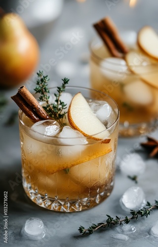 Delicious cocktail with pear slices and cinnamon served in elegant glassware ...
