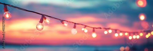 String lights glowing against a colorful sunset sky during an evening gathering