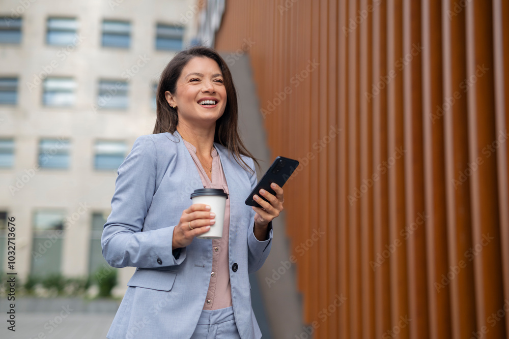 Business woman walking outdoor holding cup of coffee and phone Business woman walking outdoor holding cup of coffee and phone