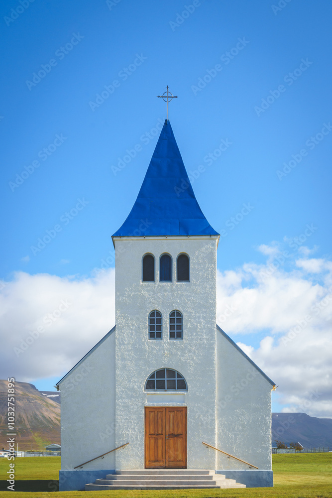 Front view of the Hofsós Church in Iceland, featuring a white facade and blue roof against a clear sky. Front view of the Hofsós Church in Iceland, featuring a white facade and blue roof against a clear sky.
