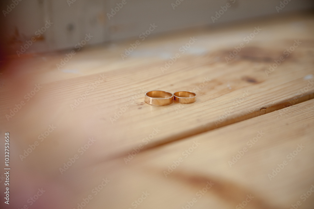 Obraz premium wedding rings on a wooden table background