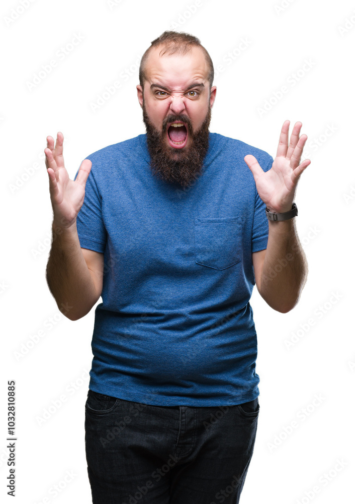 Naklejka premium Young caucasian hipster man over isolated background crazy and mad shouting and yelling with aggressive expression and arms raised. Frustration concept.