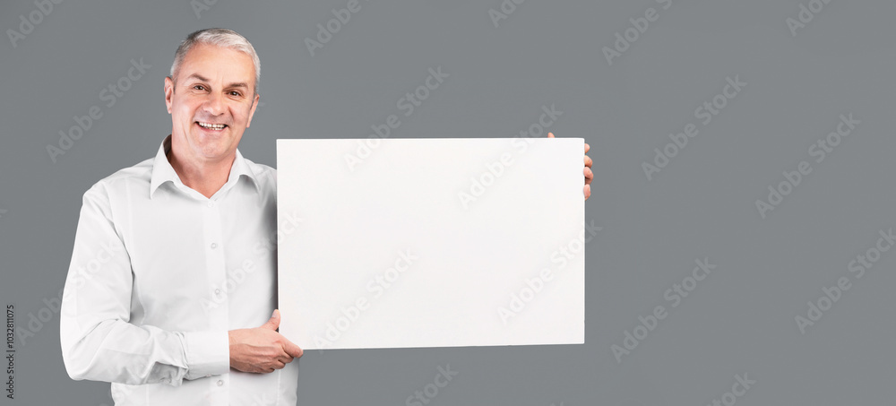 Happy Mature Man Showing Blank Placard With Copy Space For Your Text Isolated Over Gray Studio Wall Happy Mature Man Showing Blank Placard With Copy Space For Your Text Isolated Over Gray Studio Wall